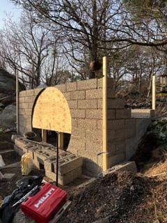 Lecaväggar muras runt plywoodformen till jordkällarens runda dörr. Lecaväggar muras runt plywoodformen till jordkällarens runda dörr.