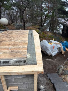 Gjuten kantbalk på jordkällarens takform med uppstickande armering. Gjuten kantbalk på jordkällarens takform med uppstickande armering.